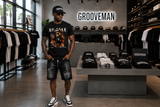 Black Island men’s distressed denim shorts with chain detail styled with a Grooveman graphic T-shirt at the Grooveman Miami Beach store