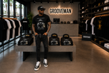 Black Island men’s black distressed jeans with chain and front zipper styled with a Grooveman graphic T-shirt in Miami Beach