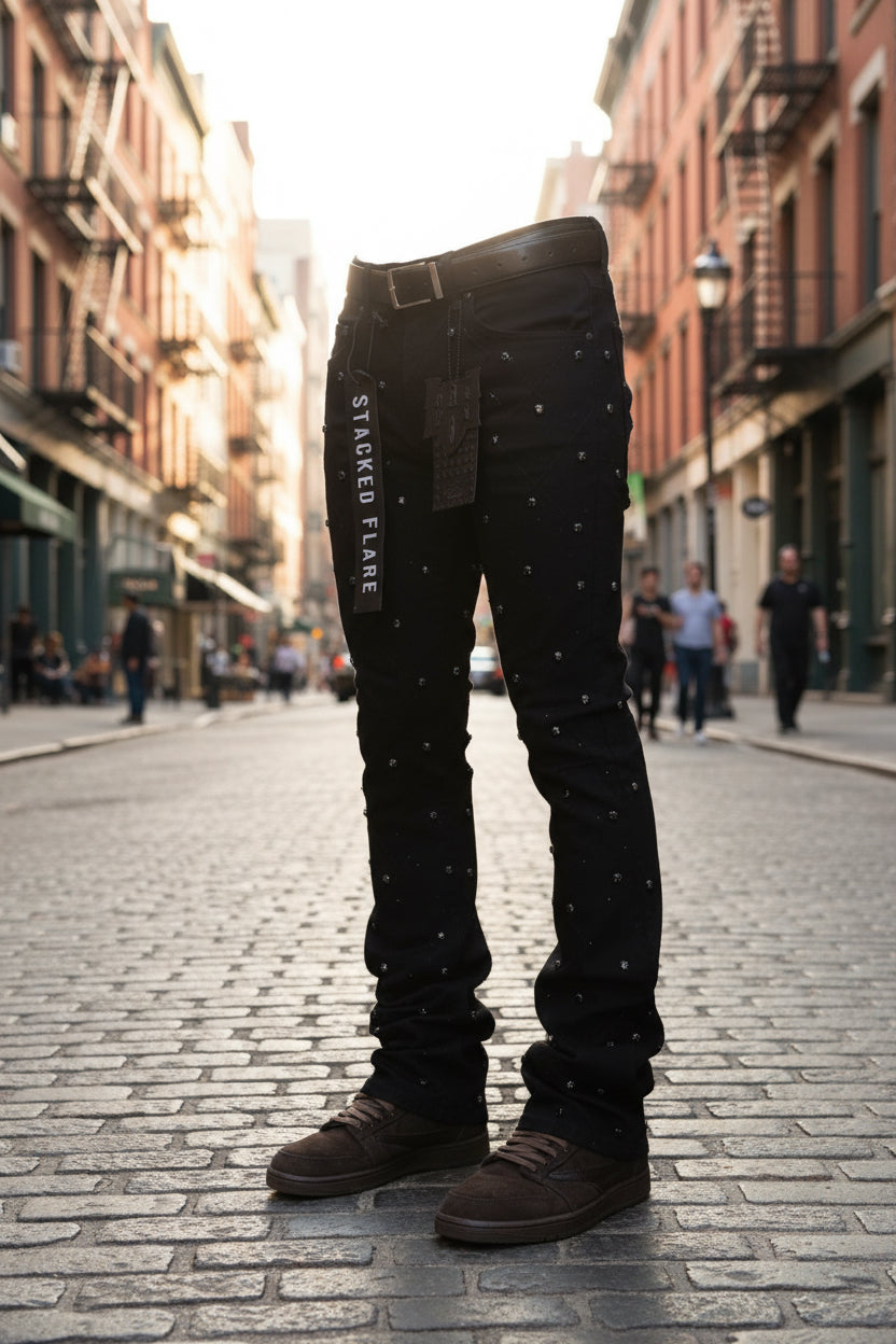 Black jeans with 'Stacked Flare' label on a white background