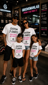 A family of four posing together inside a Groovemanlab retail store, wearing matching white custom graphic t-shirts with black and pink text.