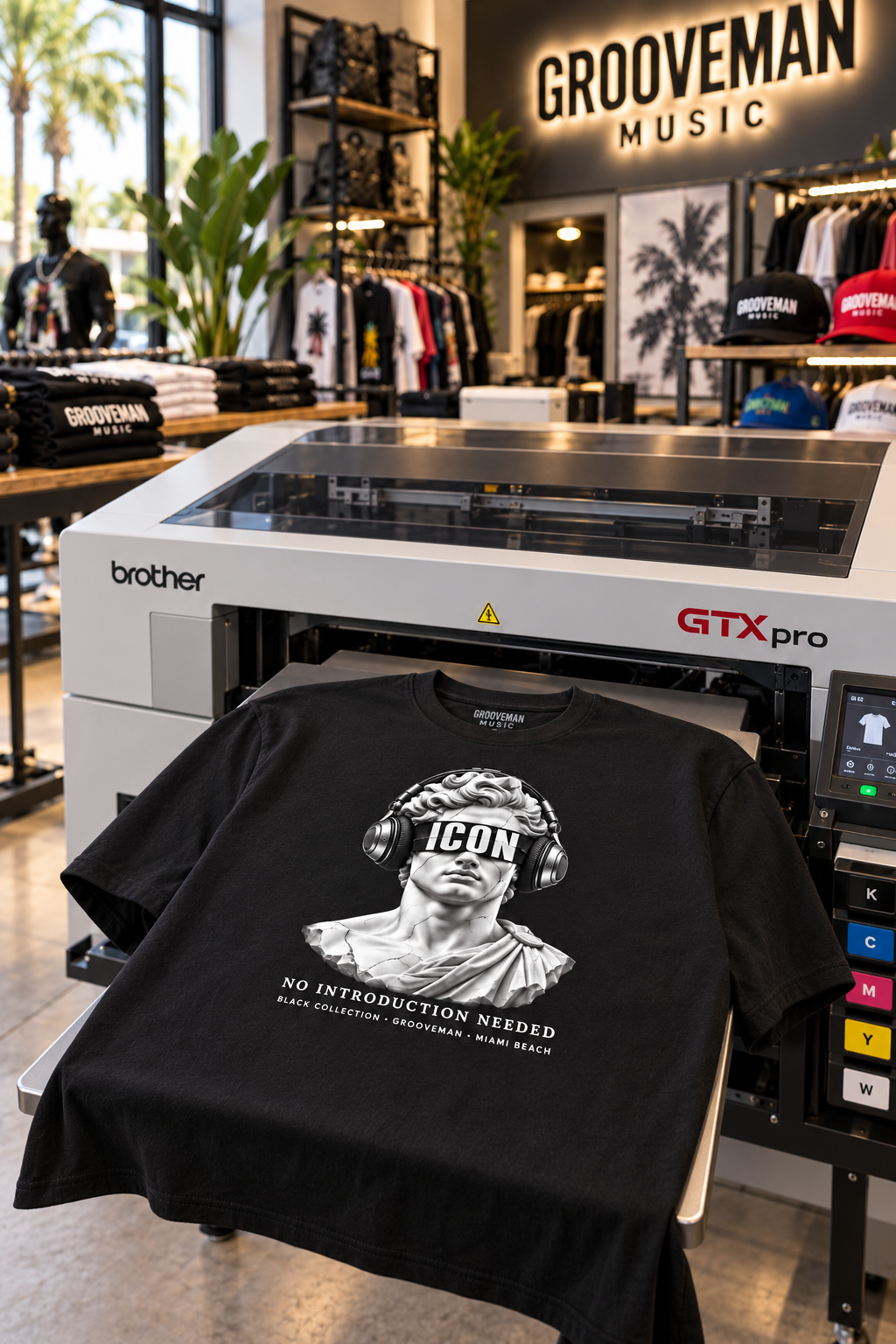 Black ICON headphones graphic T-shirt on a Brother GTX Pro DTG printer platen at Grooveman Music in Miami Beach.