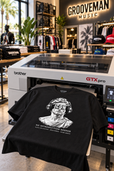 Black ICON headphones graphic T-shirt on a Brother GTX Pro DTG printer platen at Grooveman Music in Miami Beach.