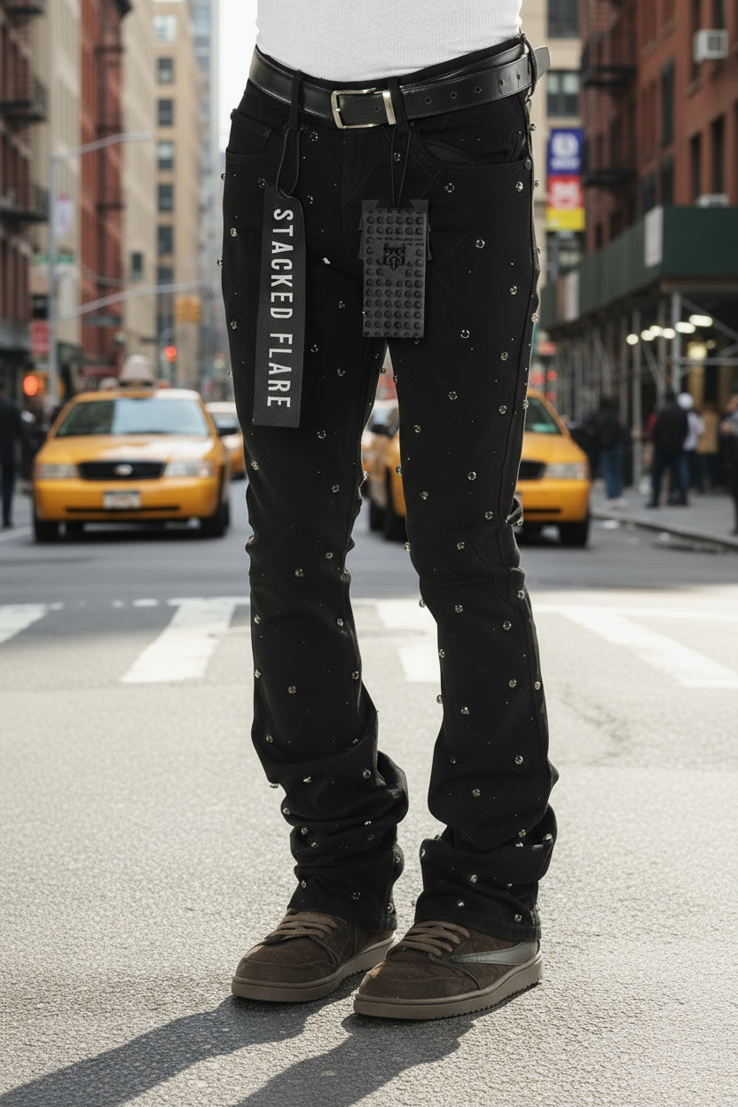 Black flared jeans with decorative elements on a white background
