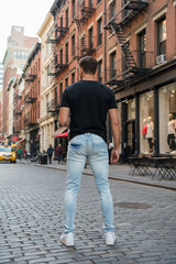 Light blue jeans worn by a person on a white background