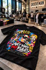 Black Art Has No Rules graffiti T-shirt displayed on a concrete table with folded tees and blurred shoppers behind.