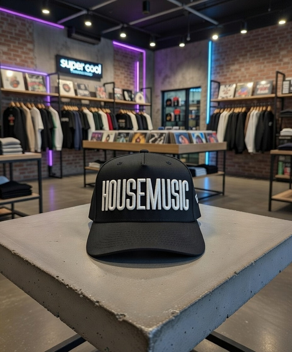 Black cap with 'HOUSEMUSIC' text on a table in a store setting