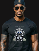 Man wearing a black t-shirt with a graphic design of a bear and text, standing on a city street.