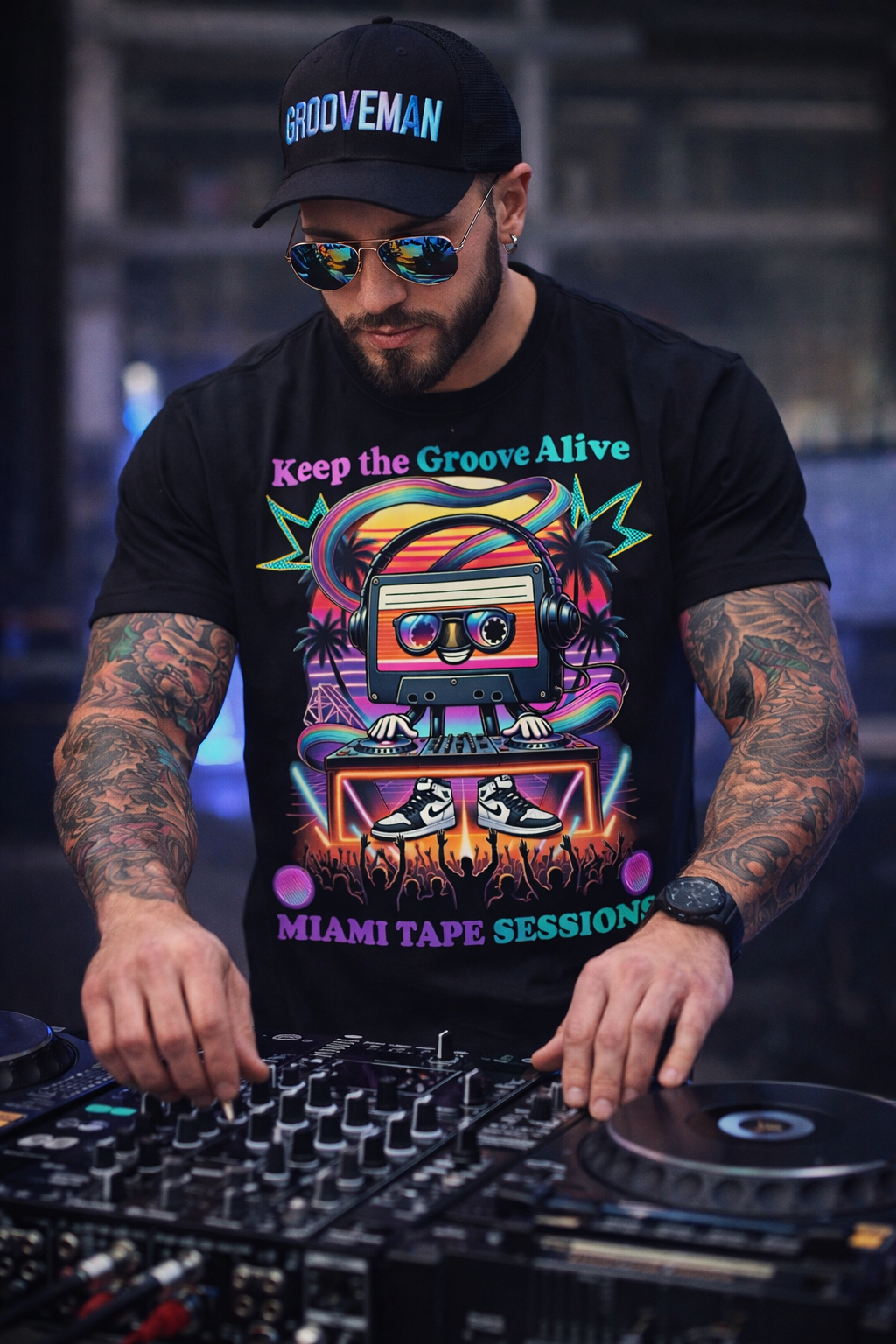 DJ wearing a 'Grooveman' cap and 'Keep the Groove Alive' t-shirt, working on turntables.