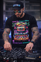 DJ wearing a 'Grooveman' cap and 'Keep the Groove Alive' t-shirt, working on turntables.