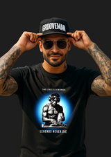 Man wearing a black t-shirt with a graphic design and 'Grooveman' cap in a tropical setting.