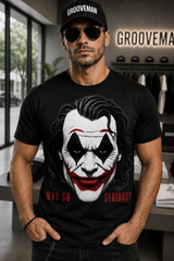 A man wearing a black Grooveman t-shirt with a large graphic of the Joker's face and the text 'WHY SO SERIOUS?' in red, paired with a black Grooveman cap in a retail store setting.
