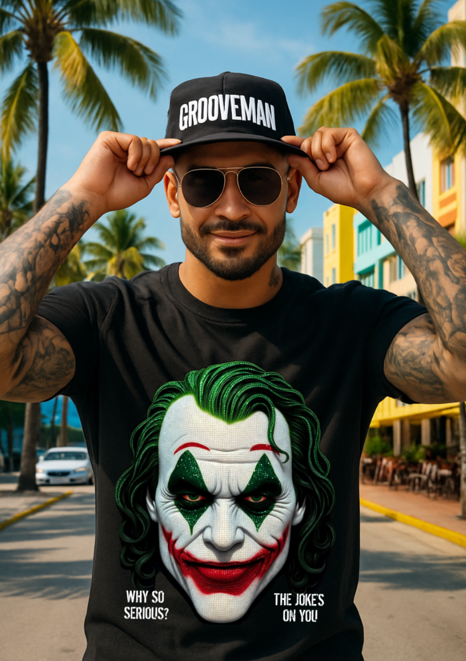 Man wearing a black t-shirt with a Joker graphic and 'Grooveman' cap in a tropical setting.