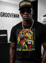 Man wearing a black t-shirt with a colorful lion graphic and 'King Mentality' text, standing in front of a 'Grooveman' branded background.