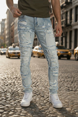 Person wearing light blue distressed jeans and white sneakers on a plain background