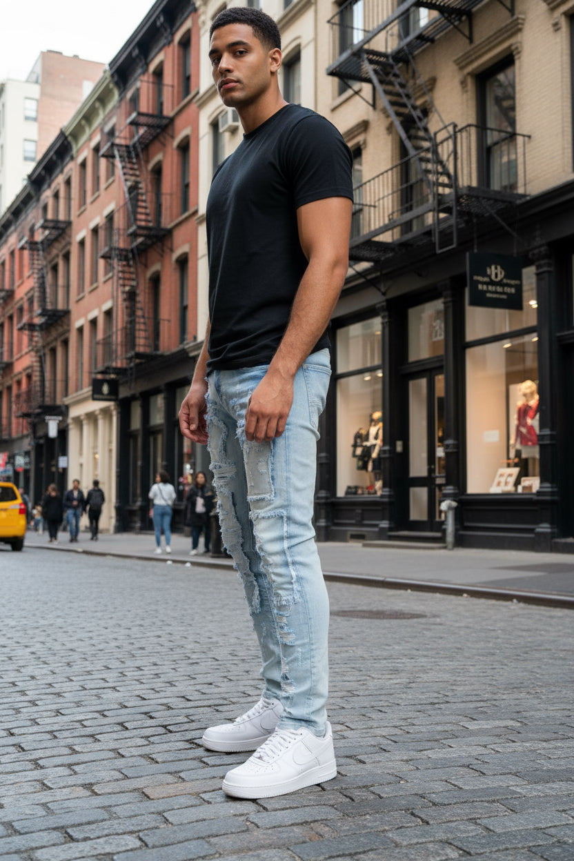 Light blue distressed jeans worn by a person on a white background