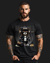 Man wearing a black t-shirt with a graphic design of a bear wearing headphones and a Miami hat.