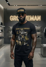 Man wearing a black t-shirt with graphic design and text, standing in a modern interior setting.