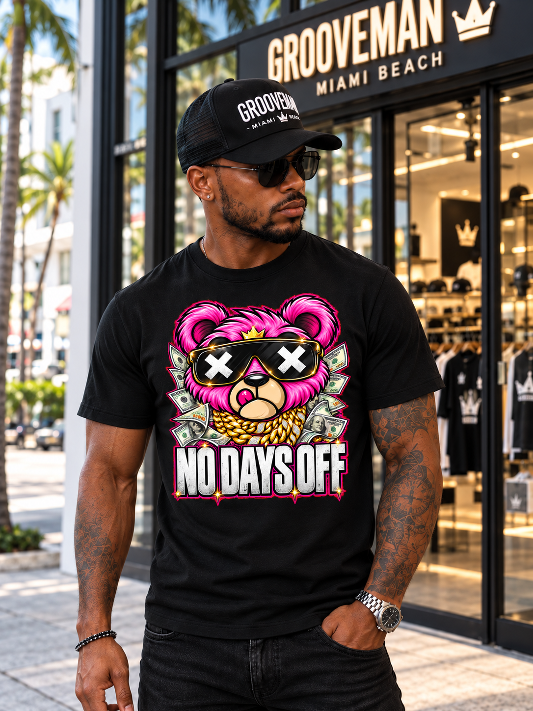 Model wearing the black No Days Off pink teddy bear T-shirt and Grooveman cap outside the storefront.