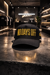Black cap with 'NO DAYS OFF' text on a reflective surface in a store setting.