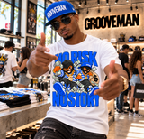 A man wearing a white t-shirt with a colorful 'No Risk No Story' graphic and a blue 'GROOVEMAN' cap, posing inside a retail store.