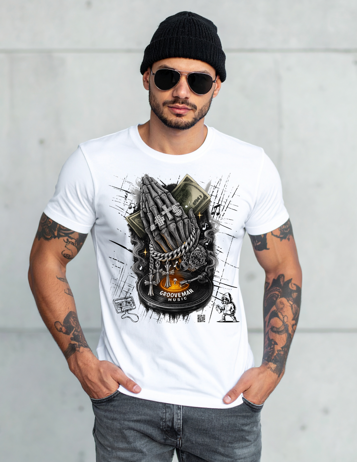 Man wearing a white t-shirt with a graphic design, black beanie, and sunglasses against a light gray background.