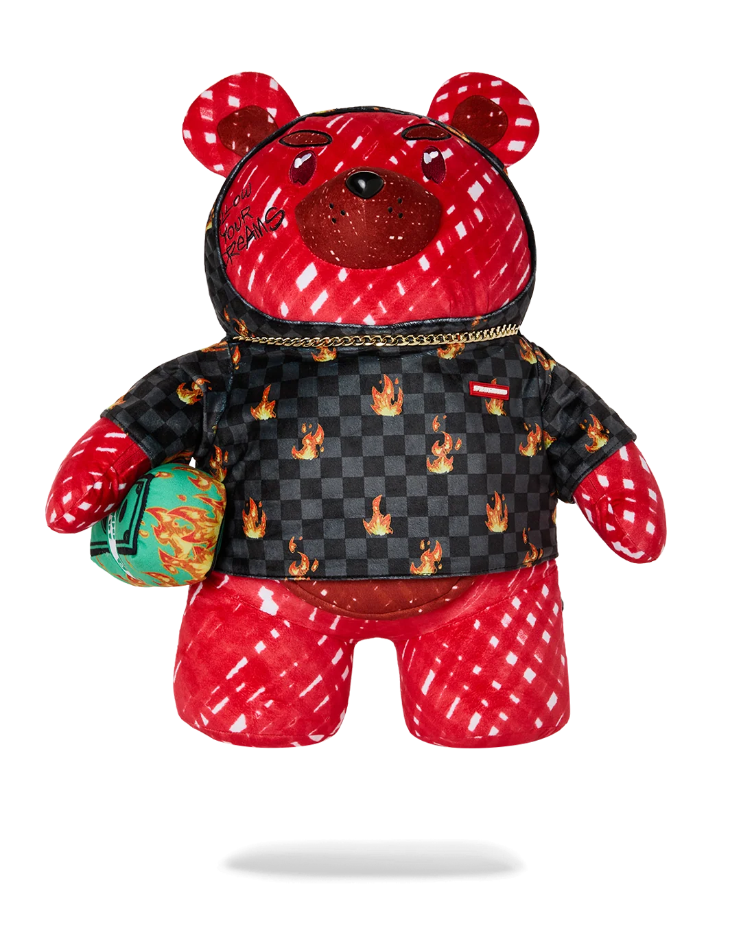 A red and black patterned teddy bear plush toy wearing a black checkered jacket with flame motifs, red patterned pants, and holding a green patterned pouch, shown against a plain white background.