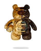 A split-design teddy bear plush toy, featuring one half in gold velvet with a dollar sign and the other half in a dark brown and black checkered pattern, set against a plain white background.