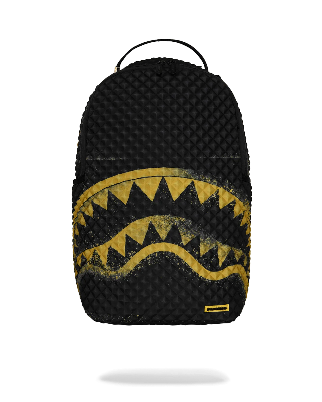 A black textured backpack featuring a distressed yellow shark mouth graphic across the lower half, with a small yellow brand tab near the bottom right corner, shown against a plain white background.