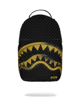 A black textured backpack featuring a distressed yellow shark mouth graphic across the lower half, with a small yellow brand tab near the bottom right corner, shown against a plain white background.