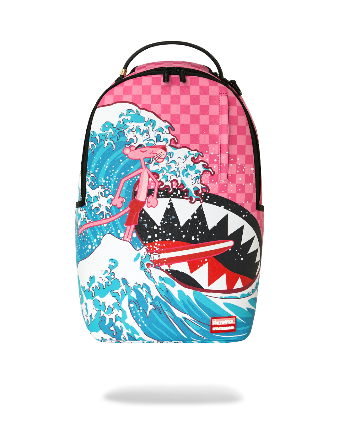 A backpack featuring a graphic print of the Pink Panther surfing on a giant shark wave, styled after 'The Great Wave off Kanagawa'. The top portion of the backpack has a pink and white checkerboard pattern, and the brand label 'SPRAYGROUND' is visible in a red box near the bottom right.