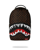 A Sprayground shark-mouth backpack featuring a brown and black checkered pattern, with a large graphic of white and red shark teeth across the lower front.