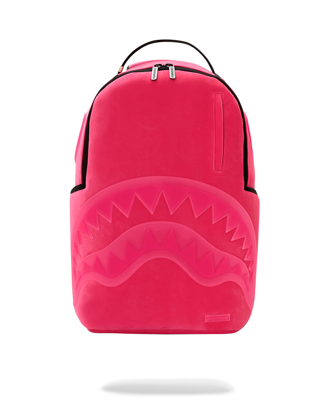 A bright pink Sprayground shark backpack with a large embossed shark mouth design on the front, black trim, and a top carry handle, shown against a plain white background.
