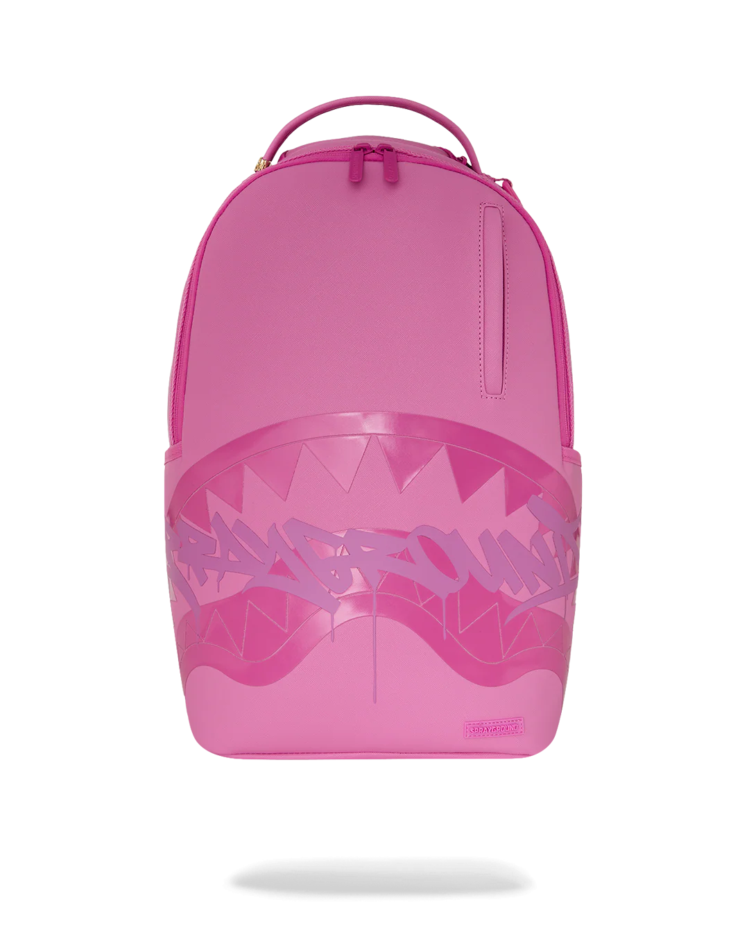 A bright pink Sprayground backpack featuring a large shark-mouth graphic with white teeth and a stylized spray-paint logo across the front, shown on a white background with a soft shadow underneath.