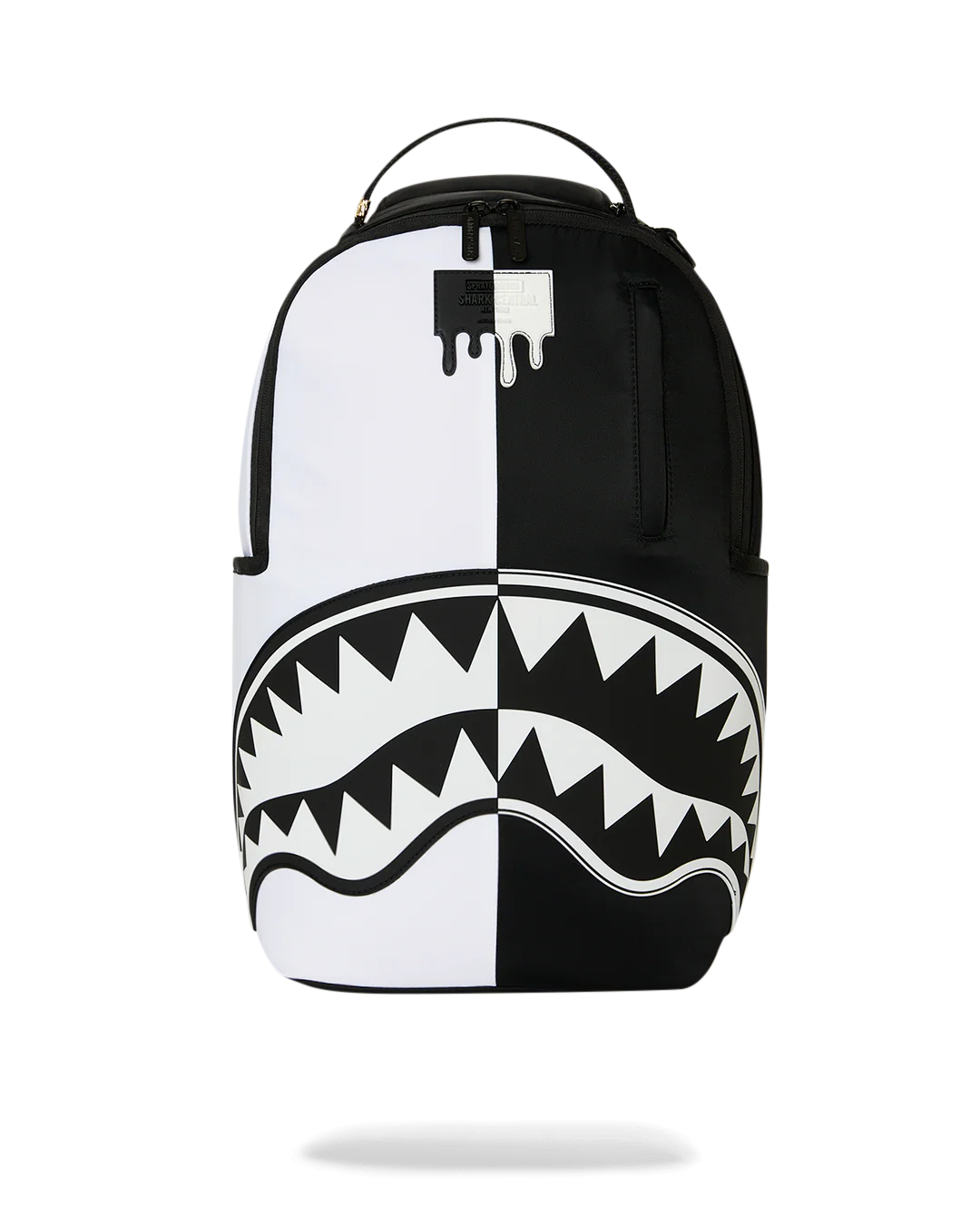 A black and white backpack featuring a split design with a dripping paint logo on the upper back and a shark-mouth graphic across the lower half, shown against a plain white background.