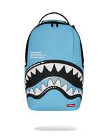 A light blue Sprayground Shark Central backpack featuring a large shark mouth graphic with white and black teeth across the lower front, plus a small red Sprayground logo patch near the bottom right.