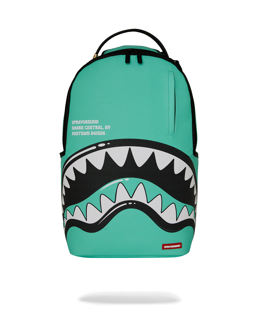 A turquoise Sprayground Shark Backpack with a large shark mouth graphic on the front, featuring white and black teeth, a top handle, and a small red Sprayground logo patch at the bottom right.