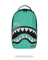 A turquoise Sprayground Shark Backpack with a large shark mouth graphic on the front, featuring white and black teeth, a top handle, and a small red Sprayground logo patch at the bottom right.