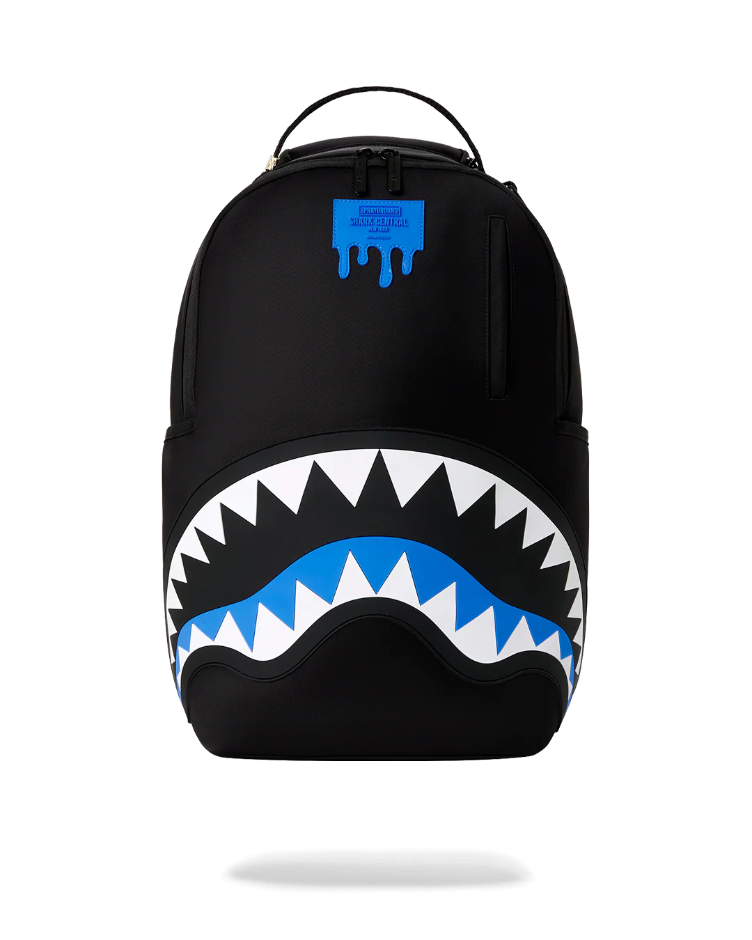 A black backpack featuring a large shark mouth graphic on the front, with white and blue details, and a blue dripping logo patch near the top.