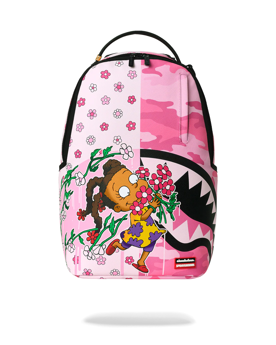 A pink backpack featuring a split design: one half has a white background with pink cherry blossoms, and the other half has a pink camouflage pattern. The front also features a cartoon girl holding pink flowers and a shark mouth graphic.