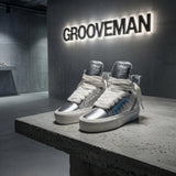 Silver high-top sneakers on a concrete platform with 'GROOVEMAN' branding in the background.