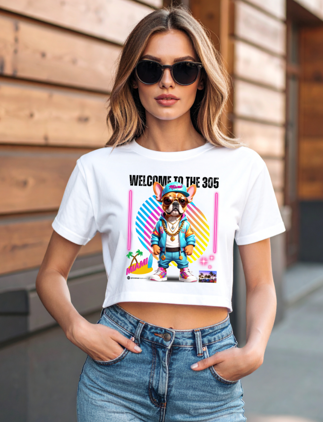 Woman wearing a white t-shirt with a graphic design and sunglasses, standing outdoors.