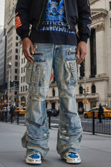 Person wearing heavily distressed blue jeans with a plain background